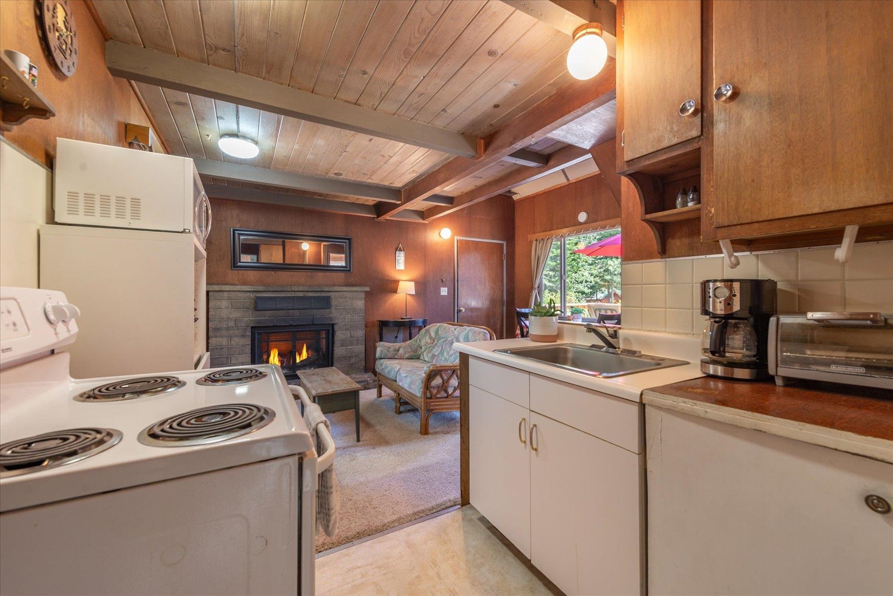 265 Old County Road Carnelian Bay, CA 96140 - Photo 19 of 28 a kitchen with stainless steel appliances granite countertop a sink a stove and a microwave