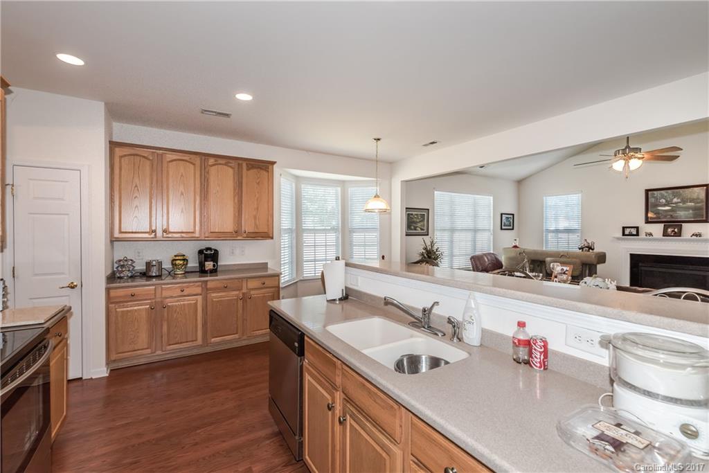 242 Garnet Court Fort Mill, SC 29708 - Photo 11 of 22 a kitchen with stainless steel appliances granite countertop a sink stove and white cabinets with wooden floor