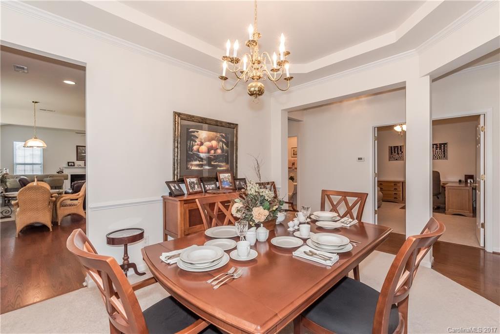 242 Garnet Court Fort Mill, SC 29708 - Photo 6 of 22 a view of a dining room with furniture a chandelier and wooden floor