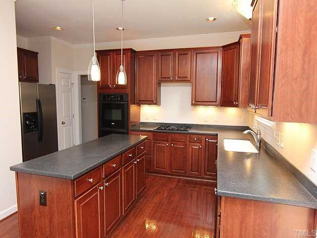 5204 6 Pence Court Raleigh, NC 27613 - Photo 4 of 17 Spacious kitchen with gas range, solid surface counters, and center island. Kitchen