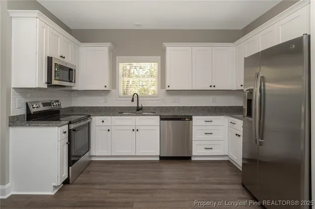 a kitchen with white cabinets and stainless steel appliances