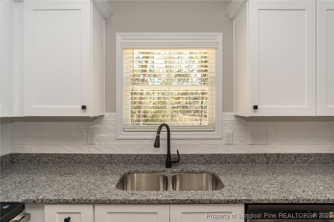229 August Lane Raeford, NC 28376 - Photo 13 of 39 a kitchen with granite countertop a sink and a window