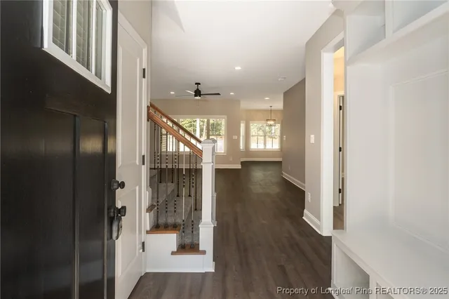 a view of a hallway with wooden floor and staircase