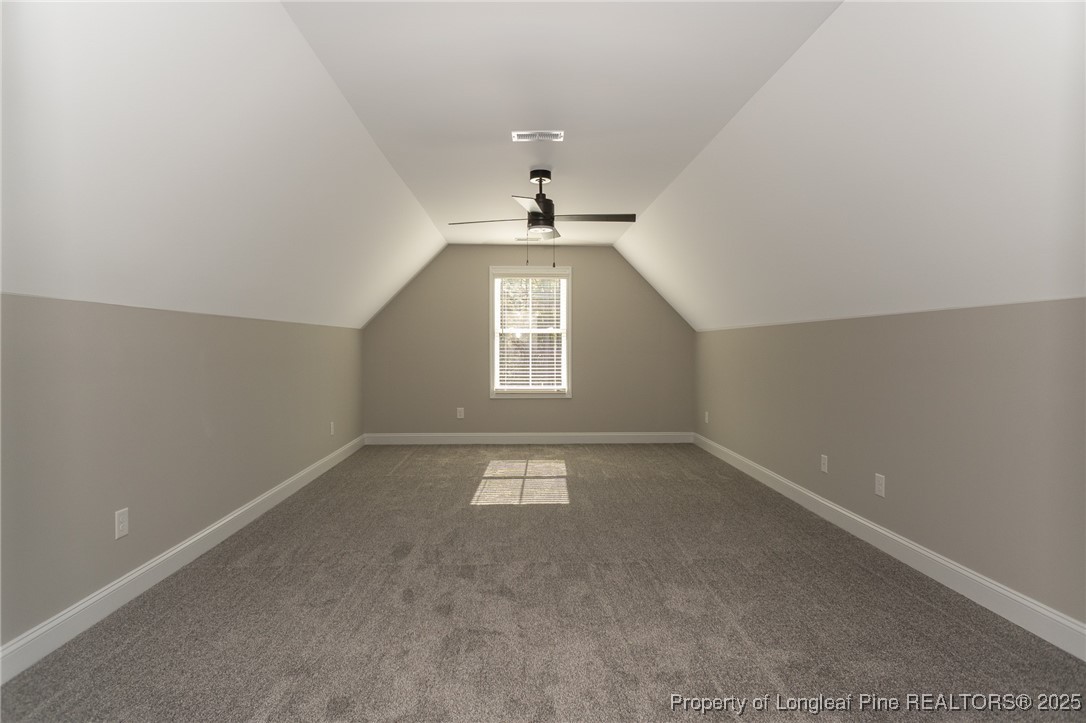 229 August Lane Raeford, NC 28376 - Photo 31 of 39 an empty room with a chandelier fan and windows