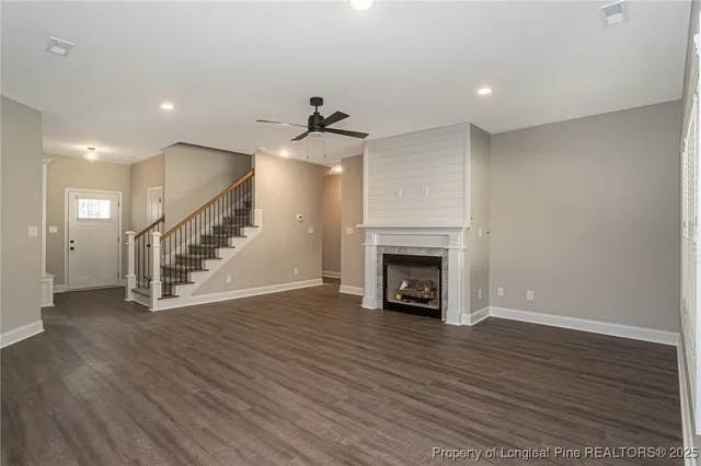 an empty room with wooden floor staircase and a fireplace