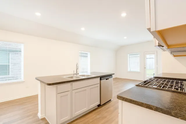 a kitchen with a sink stove and cabinets