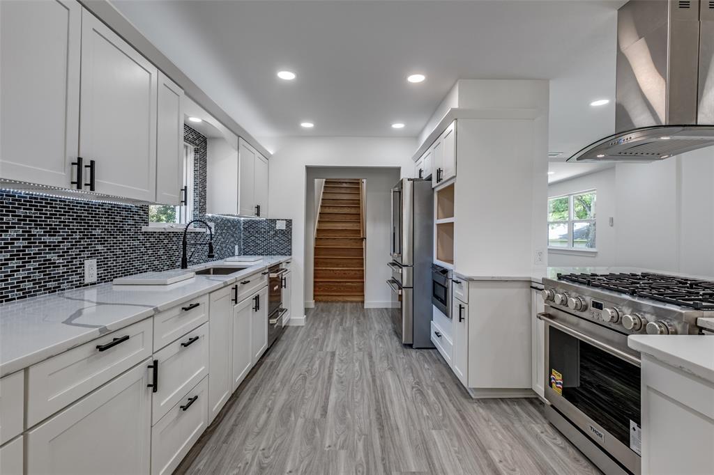 11341 Gatewood Place Dallas, TX 75218 - Photo 17 of 29 a kitchen with stainless steel appliances sink stove refrigerator and cabinets