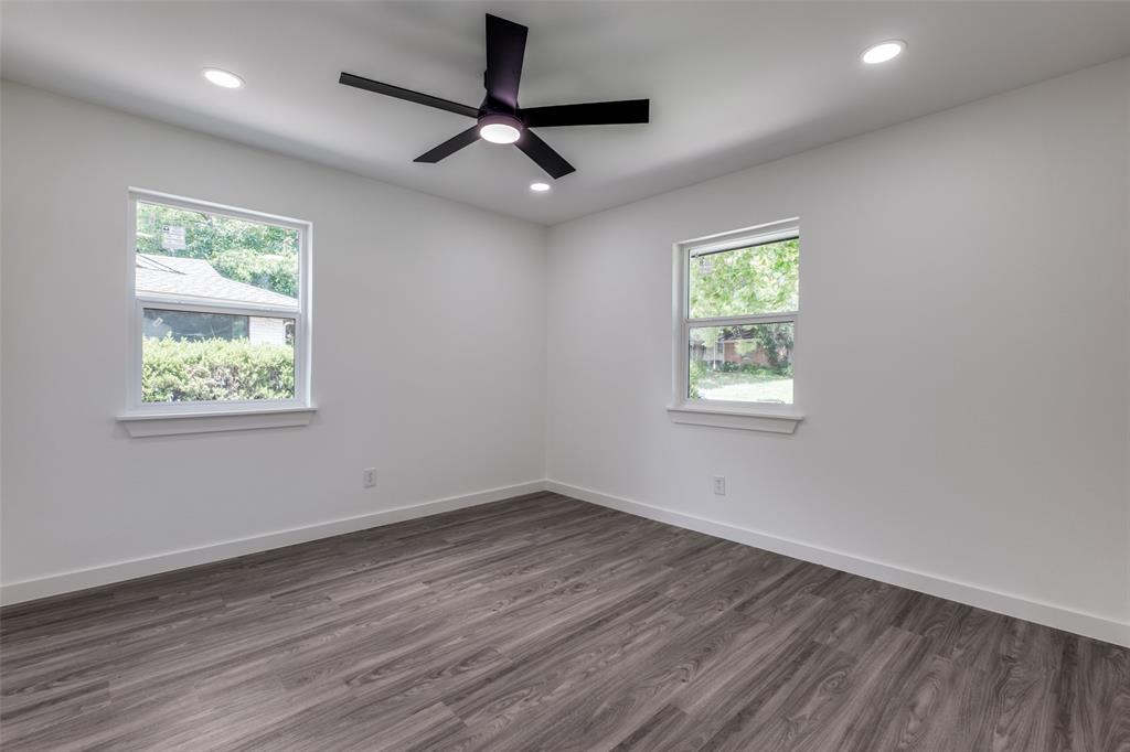 11341 Gatewood Place Dallas, TX 75218 - Photo 24 of 29 an empty room with wooden floor ceiling fan and windows