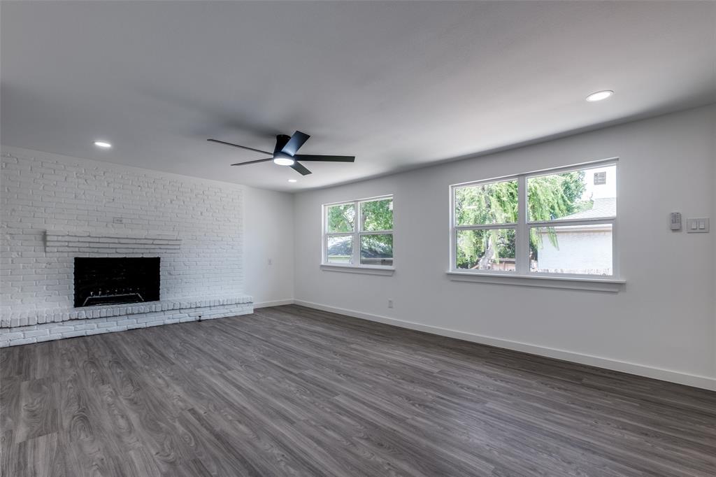 11341 Gatewood Place Dallas, TX 75218 - Photo 9 of 29 an empty room with windows fireplace and a ceiling fan