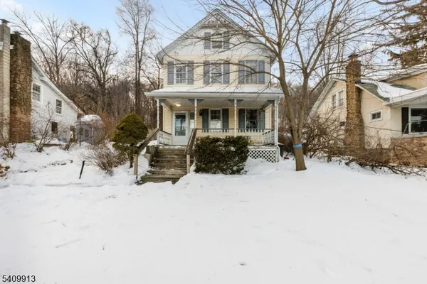 a front view of house with yard covered in snow