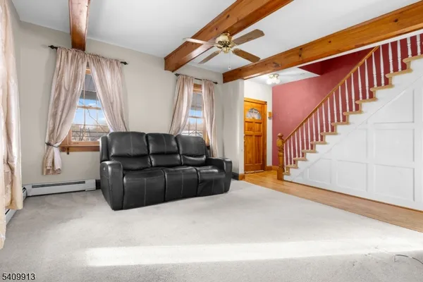 a living room with wooden floor and stairs