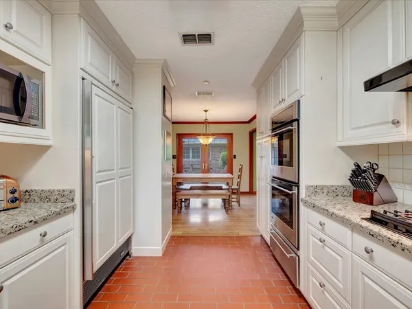 a kitchen with granite countertop a refrigerator stove top oven a sink and dishwasher