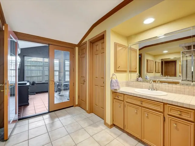 a spacious bathroom with a shower a sink and a mirror
