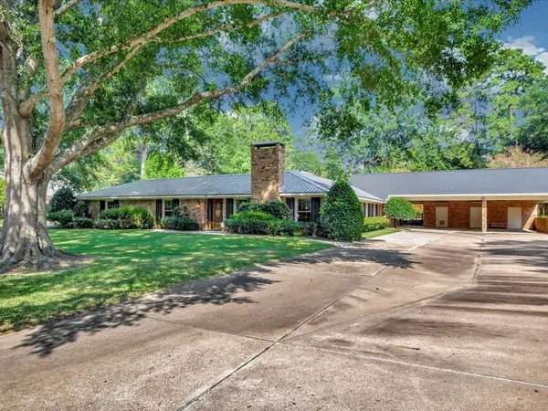 a front view of a house with a yard and potted plants
