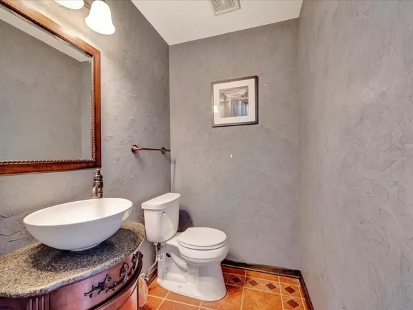 a bathroom with a toilet a sink and mirror