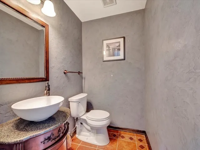 a bathroom with a toilet a sink and mirror