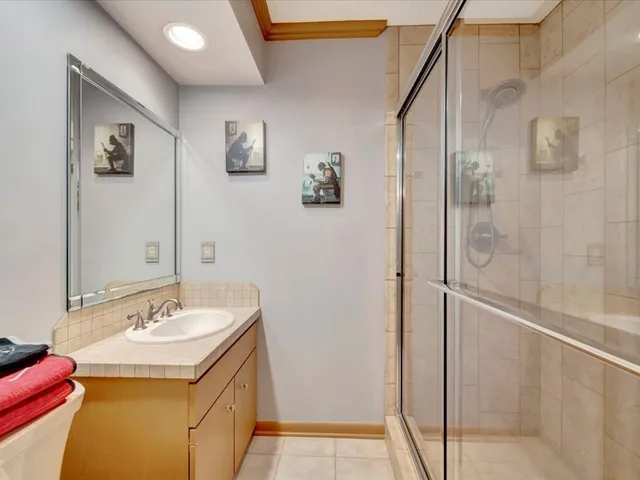 a bathroom with a granite countertop sink a mirror and a shower