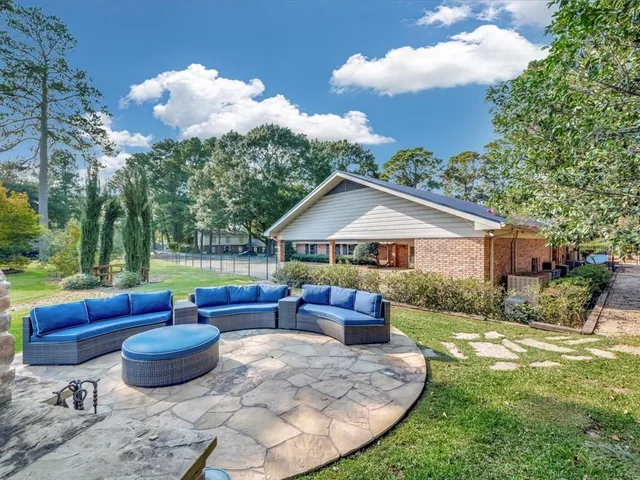 a view of a house with backyard and sitting area