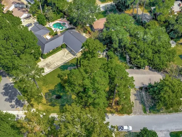 an aerial view of residential house with outdoor space and trees all around