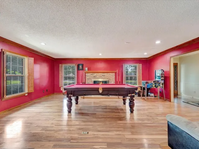 a living room with furniture a pool table and a large window