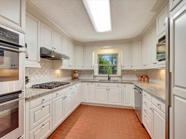 a kitchen with granite countertop white cabinets and white appliances