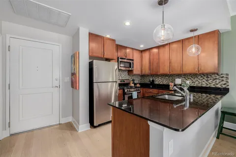 a kitchen with kitchen island granite countertop a sink refrigerator and cabinets