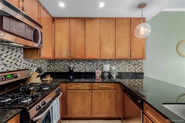a kitchen with stainless steel appliances a stove a sink a cabinets and a window