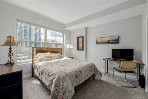 a bedroom with a bed and large windows