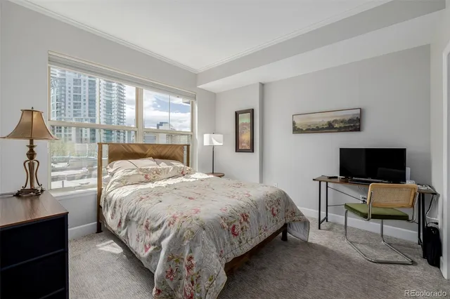 a bedroom with a bed and large windows