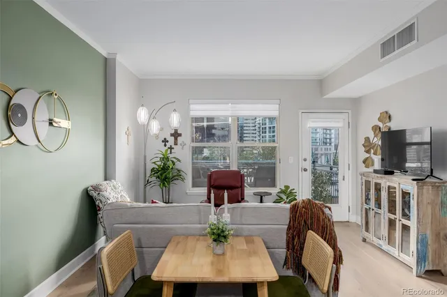a living room with furniture a flat screen tv and a large window