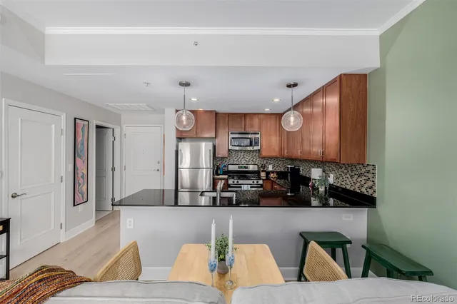 a living room with stainless steel appliances kitchen island granite countertop furniture and a view of kitchen