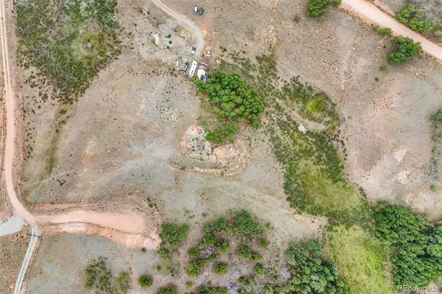 a view of a dry yard with wooden fence
