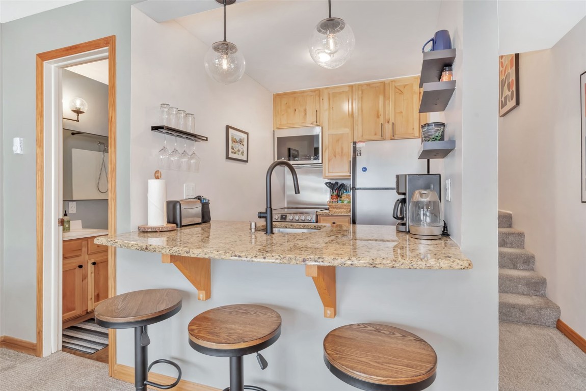 1800 Burgess Creek Road, Unit 205 Steamboat Springs, CO 80487 - Photo 13 of 37 a kitchen with stainless steel appliances granite countertop a sink and cabinets
