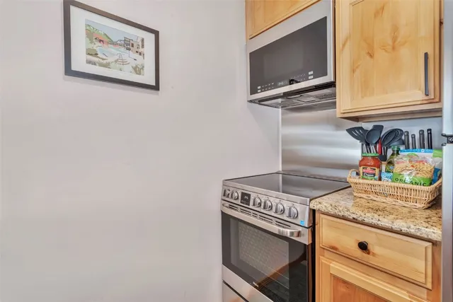 a kitchen with granite countertop a sink stove and refrigerator
