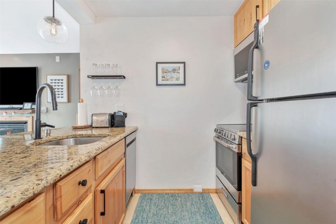 1800 Burgess Creek Road, Unit 205 Steamboat Springs, CO 80487 - Photo 17 of 37 a kitchen with granite countertop a sink stove and refrigerator