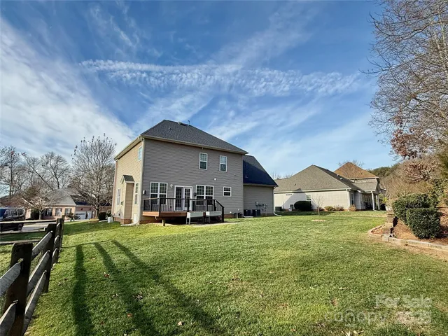 a view of a house with a big yard and large trees