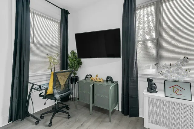 a view of a workspace with furniture and a flat screen tv