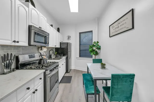 a kitchen with stainless steel appliances kitchen island granite countertop a stove a sink and a microwave