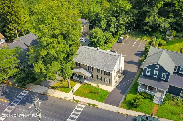 an aerial view of a house with garden space and street view