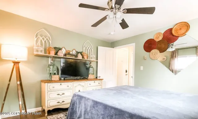 a bedroom with a bed and a flat tv screen on the dresser