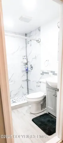 a bathroom with a sink a toilet and shower