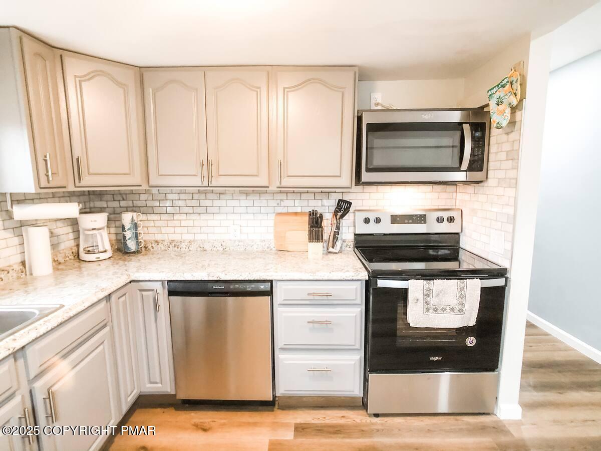 36 Main Street Delaware Water Gap, PA 18327 - Photo 30 of 37 a kitchen with stainless steel appliances granite countertop a sink a stove and a microwave