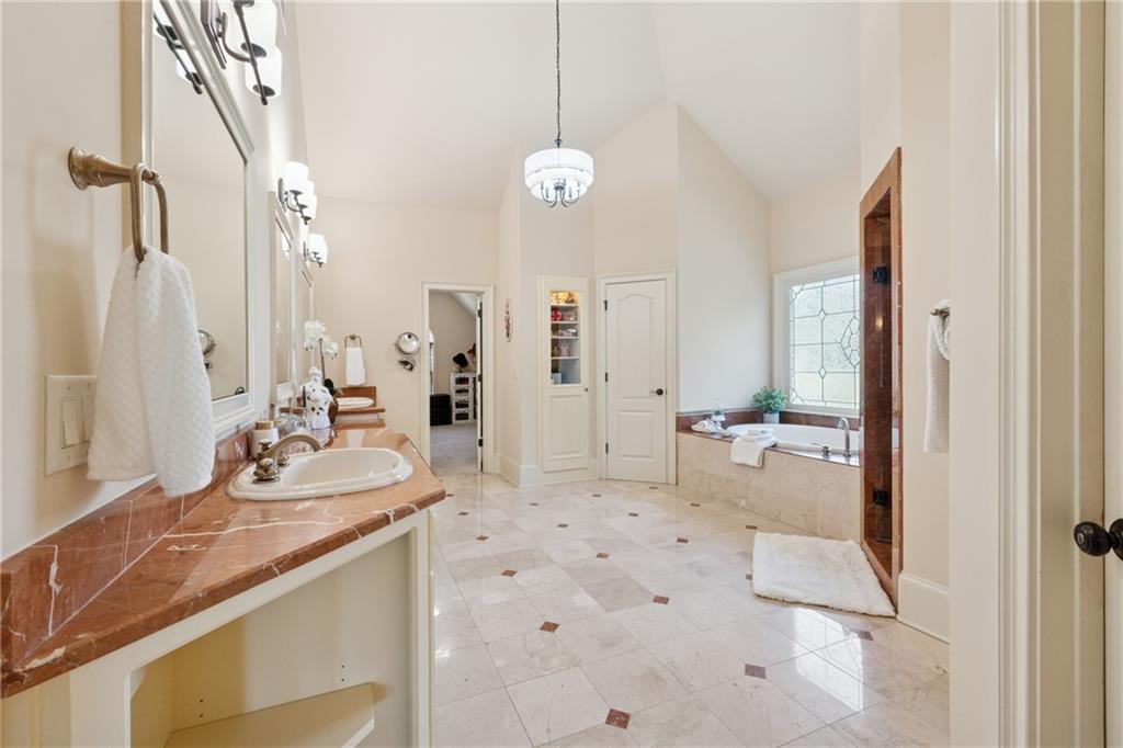 6935 Wakehurst Place Cumming, GA 30040 - Photo 45 of 92 a bathroom with a double vanity sink a mirror a bathtub and shower