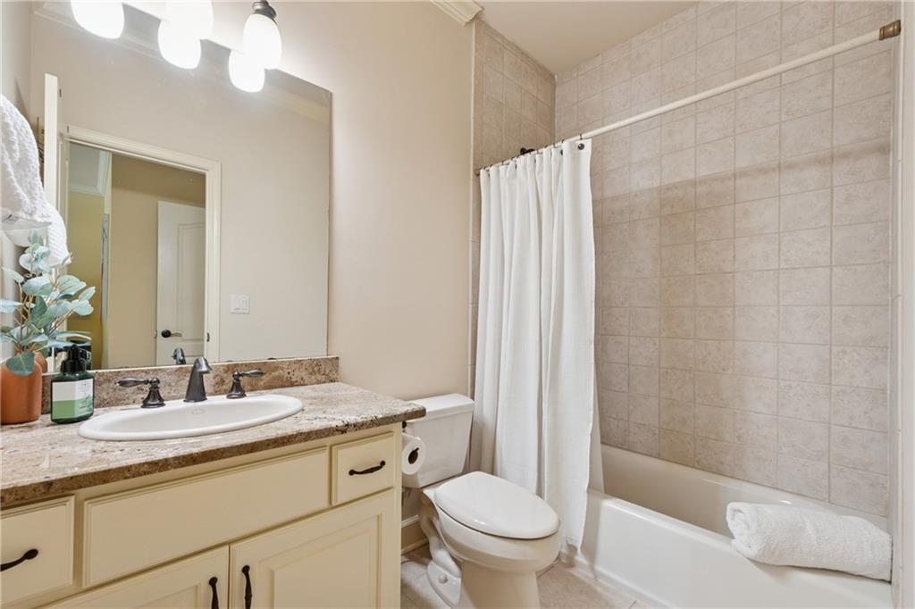 6935 Wakehurst Place Cumming, GA 30040 - Photo 52 of 92 a bathroom with a granite countertop sink a toilet and shower