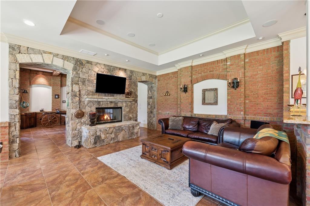 6935 Wakehurst Place Cumming, GA 30040 - Photo 60 of 92 a living room with furniture a fireplace and a flat screen tv