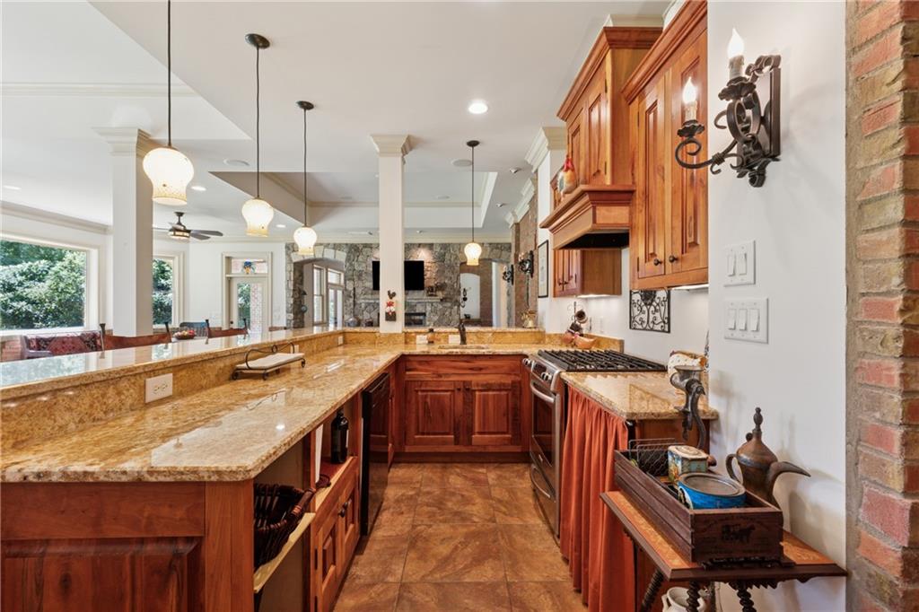 6935 Wakehurst Place Cumming, GA 30040 - Photo 68 of 92 a kitchen with stainless steel appliances granite countertop a sink a counter space and a view of living room