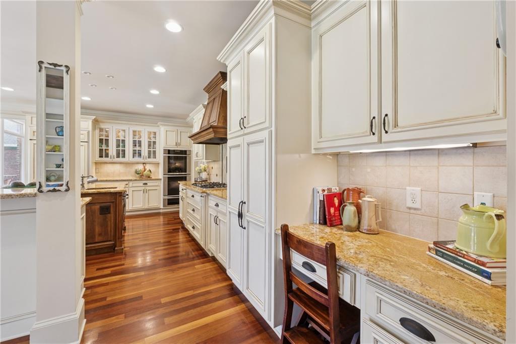 6935 Wakehurst Place Cumming, GA 30040 - Photo 10 of 92 a kitchen with granite countertop lots of counter top space and wooden floor