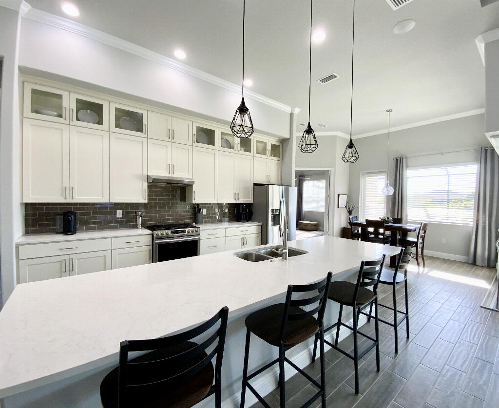 4644 Capri Lane Melbourne, FL 32935 - Photo 11 of 43 a kitchen with stainless steel appliances kitchen island granite countertop a table chairs and a refrigerator