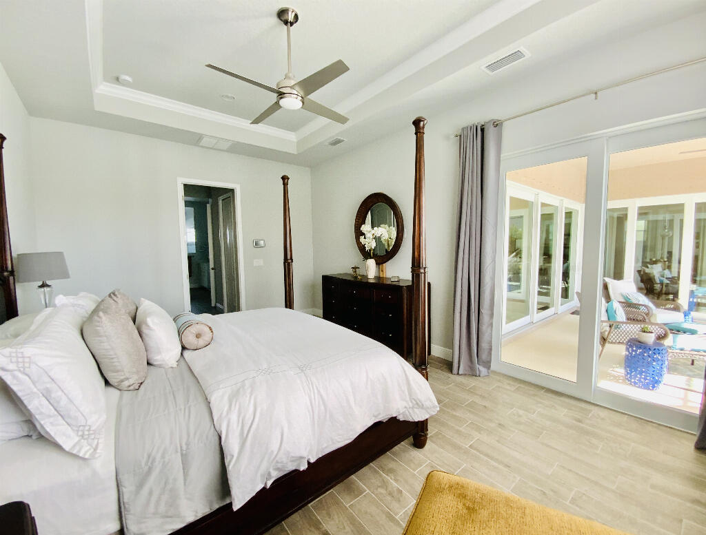 4644 Capri Lane Melbourne, FL 32935 - Photo 21 of 43 a bedroom with a bed mirror and a large window