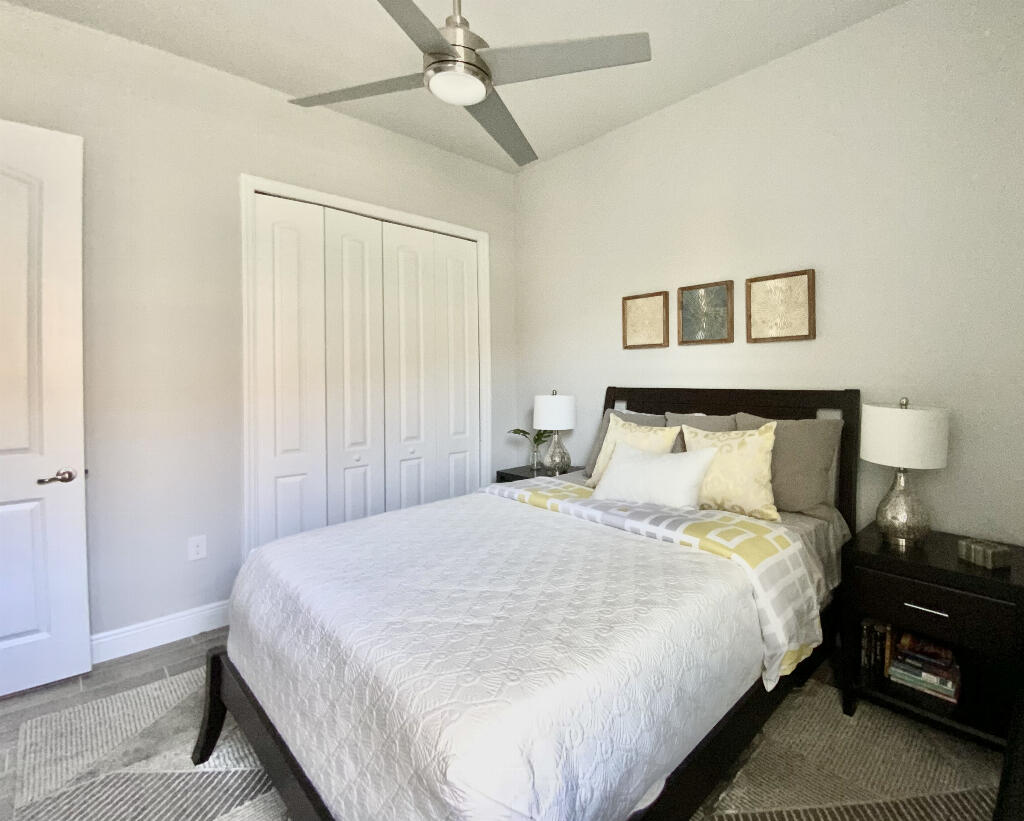 4644 Capri Lane Melbourne, FL 32935 - Photo 29 of 43 a bedroom with a bed and a night stand